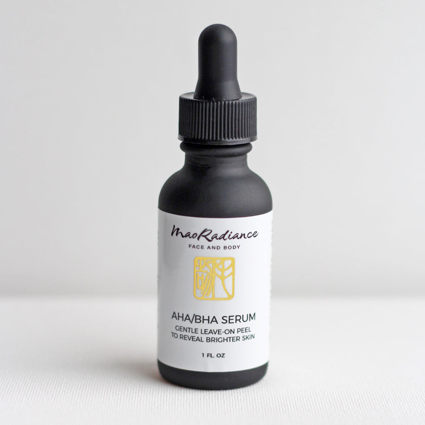 Close-up of glass bottle of AHA BHA serum from a clean beauty brand of all natural skincare products with a blend of Alpha and Beta Hydroxy Acids. The silicone free skincare serum promotes exfoliation, unclogs pores, and enhances skin texture 