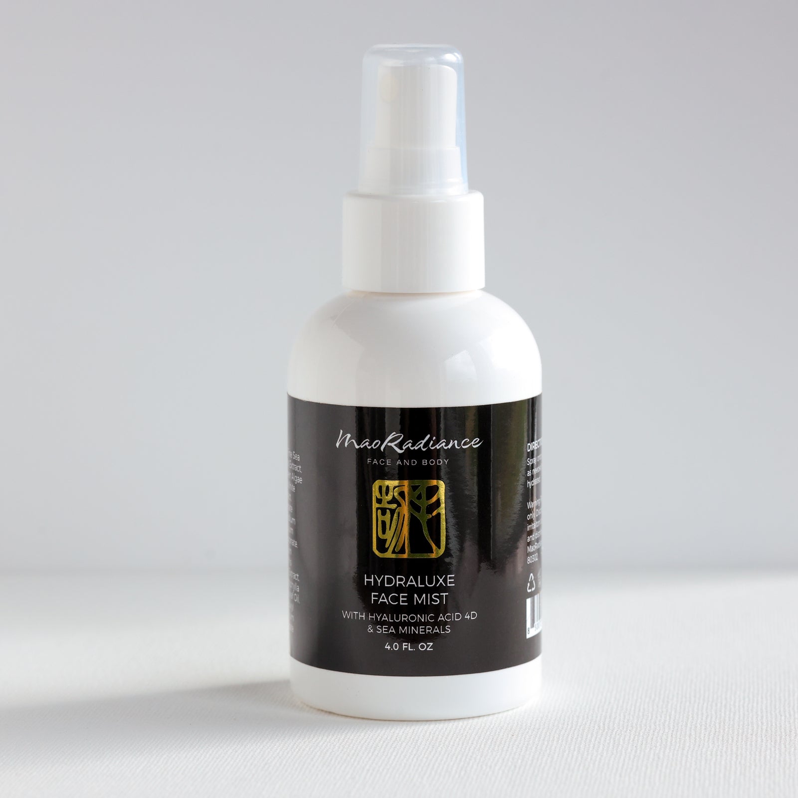 White spray bottle with black label on a light gray background
