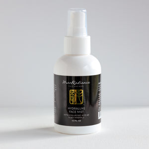 White spray bottle with black label on a light gray background