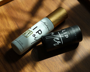 Two lip balm tubes on a wooden surface