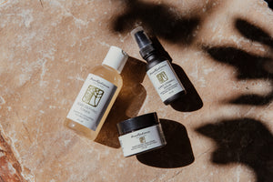 Four skincare products from the brand Mao Radiance on a textured surface with shadows.
