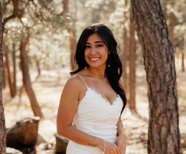 Woman in a white dress standing in a forest