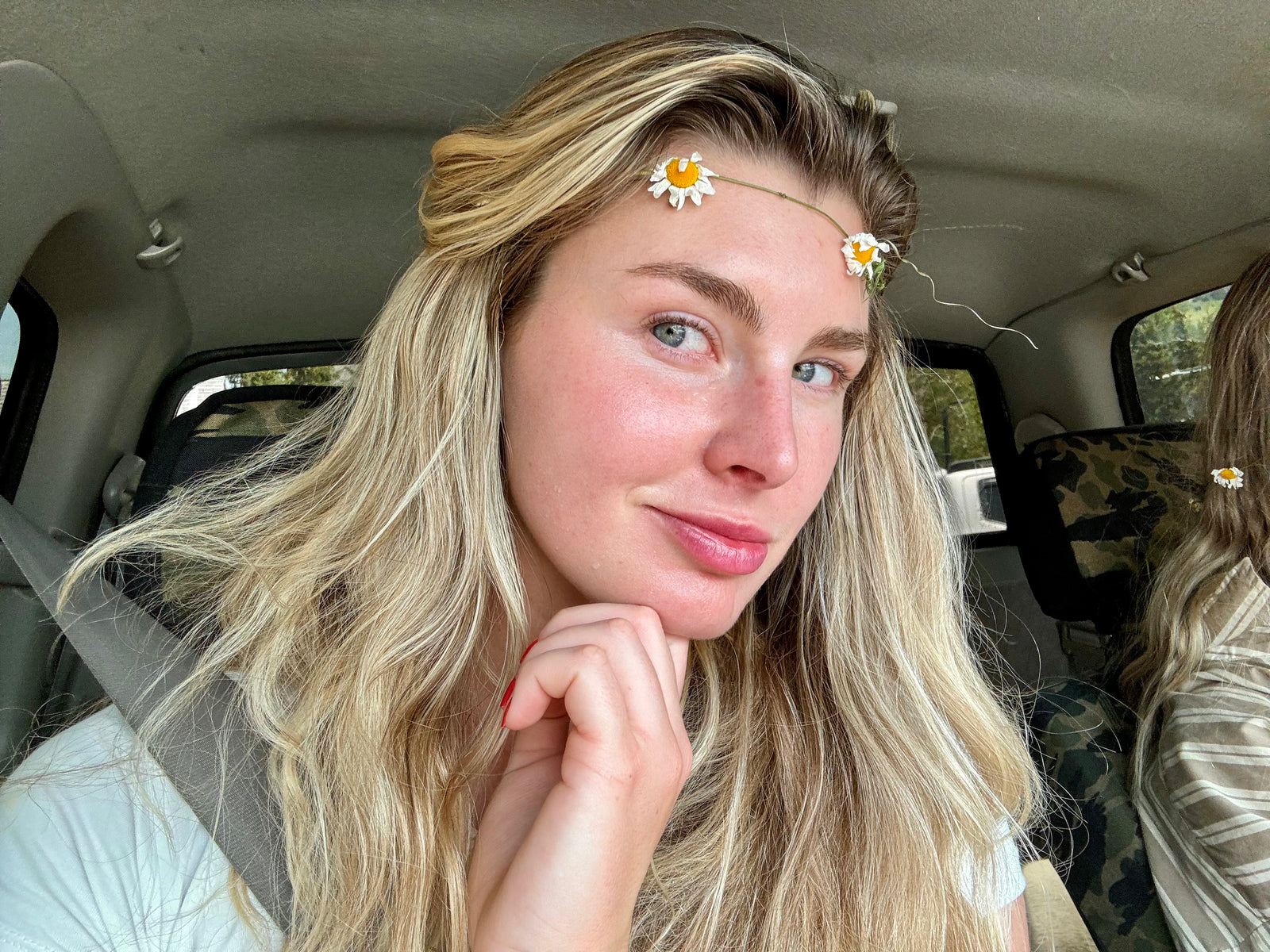 Woman smiling into camera sitting in a car.
